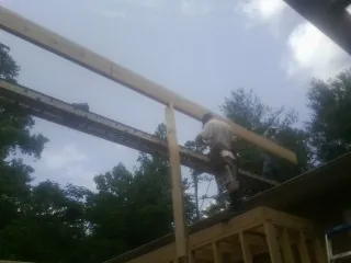 Carpenter setting a ridge beam over a new addition frame — Ice Dam Removal by Roofing Brothers in Goodhue