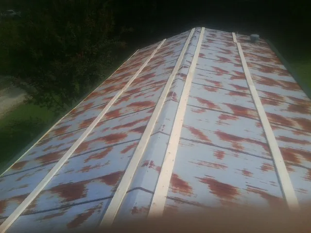 Rusted metal roof panels with new wood purlins before replacement — Storm Damage Roof Repair in Goodhue by Roofing Brothers