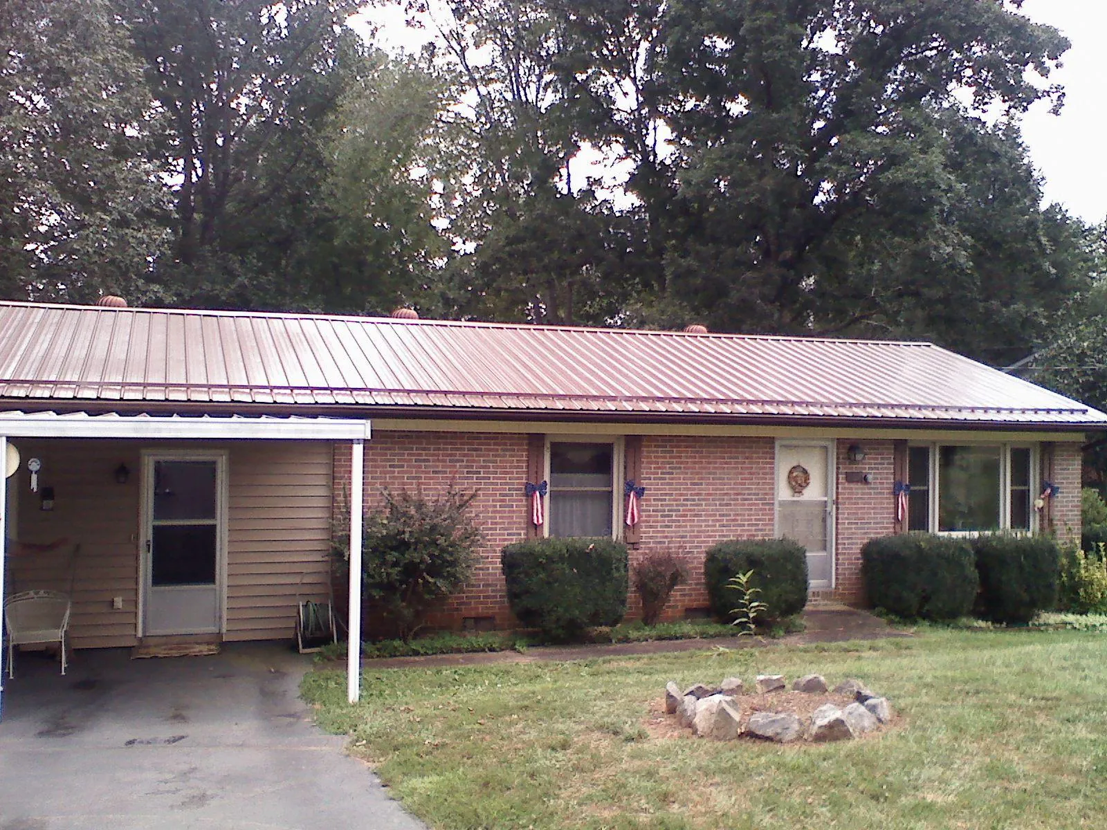 Bronze metal roof and carport on a brick ranch home — Roof Repair work by our crew in Goodhue